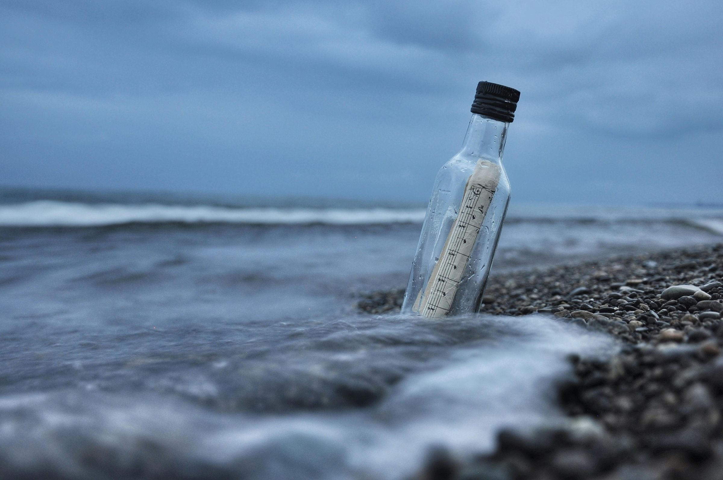 Message in a bottle on the ocean beach representing bespoke travel